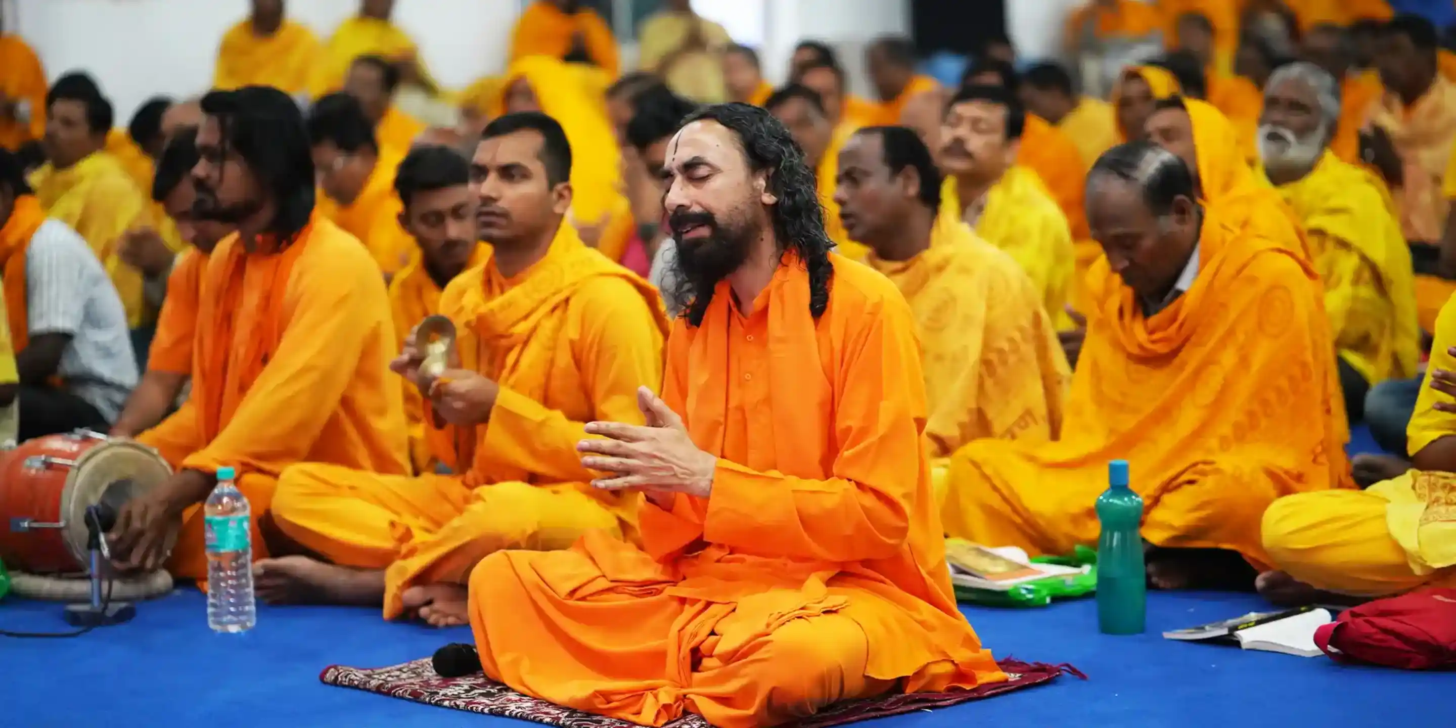  Swami Mukundananda leading a spiritual retreat with devotees in prayer.