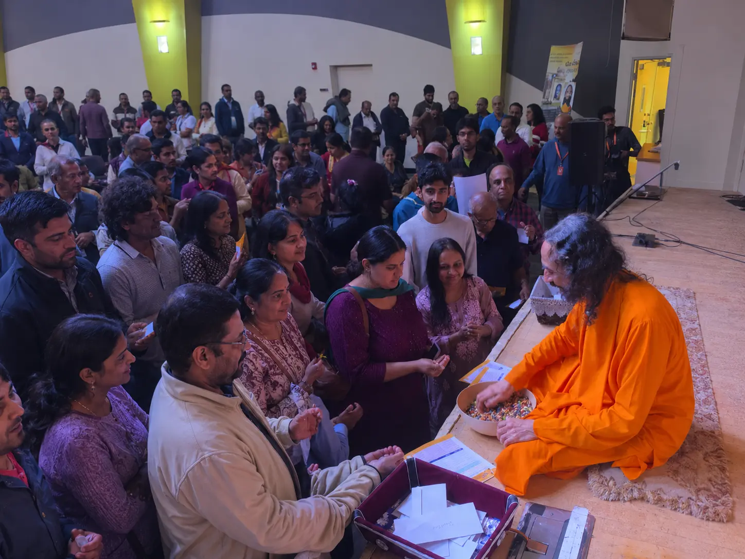 Swami Mukundananda seated on stage blessing devotees gathered in line during the Bay Area Life Transformation Program 2026.