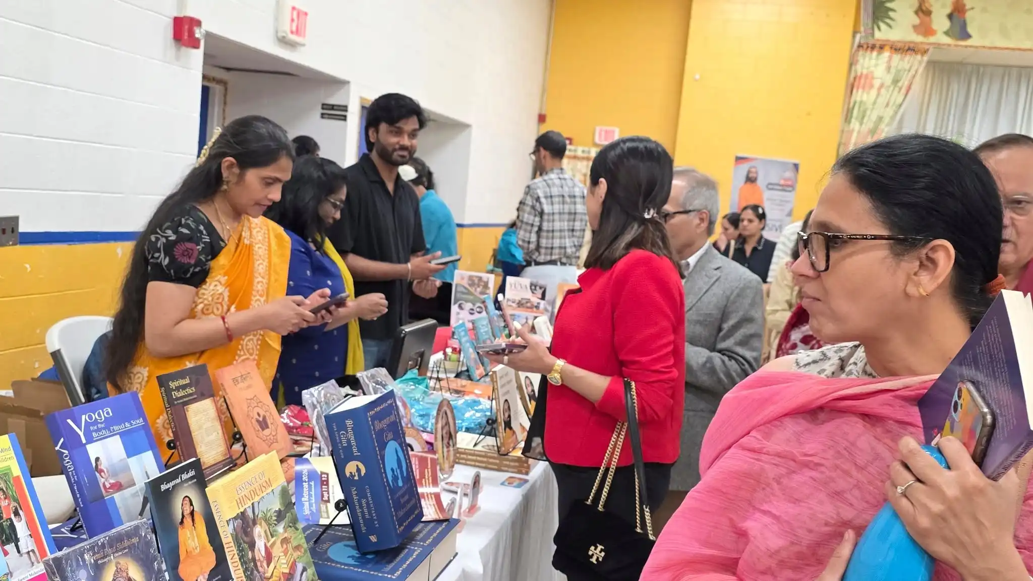Devotees browsing spiritual books at the JKYog book table during the Connecticut Life Transformation Program.