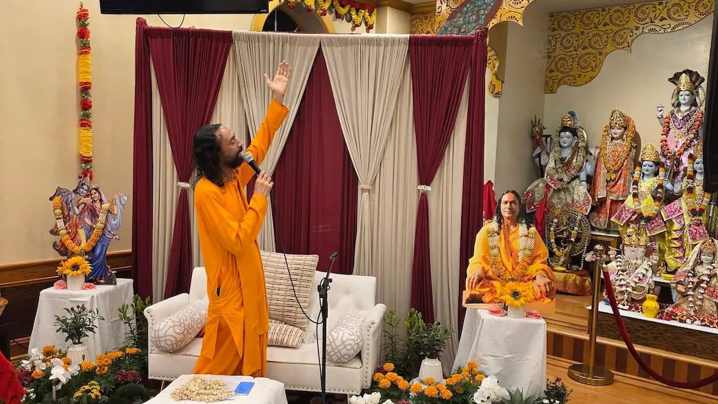 Swami Mukundananda speaking passionately during a spiritual discourse at Shree Radha Krishna Mandir.