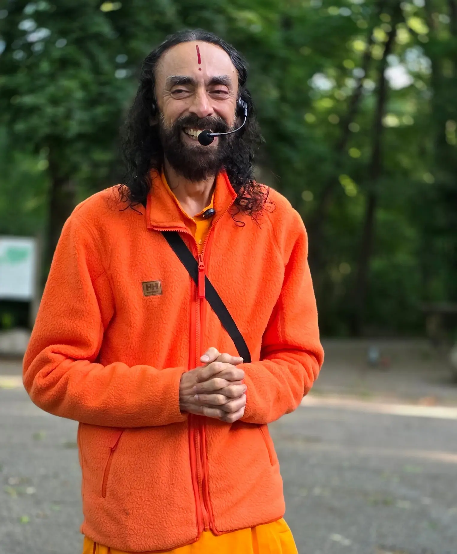 Smiling Swami Mukundananda leading a morning satsang walk in a park during the New York Life Transformation Program.