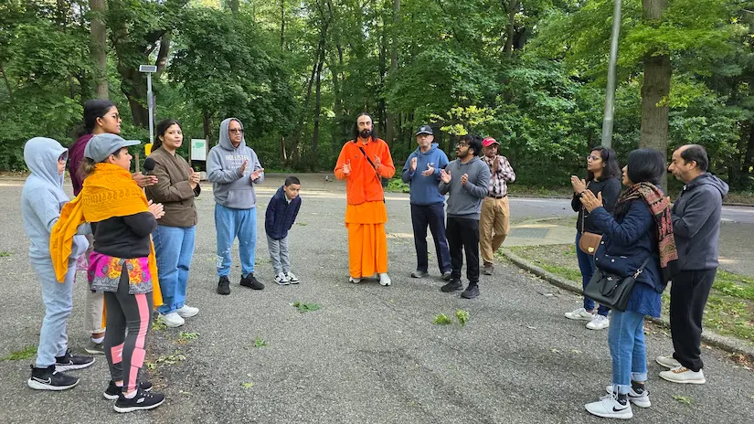 Swami Mukundananda leading a morning walk and satsang with devotees in a park during the New York Life Transformation Program.