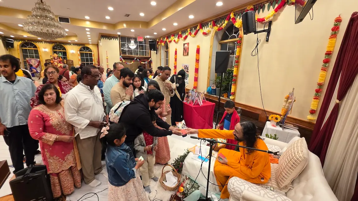 Swami Mukundananda personally distributing prasadam to devotees at the New York Life Transformation Program.
