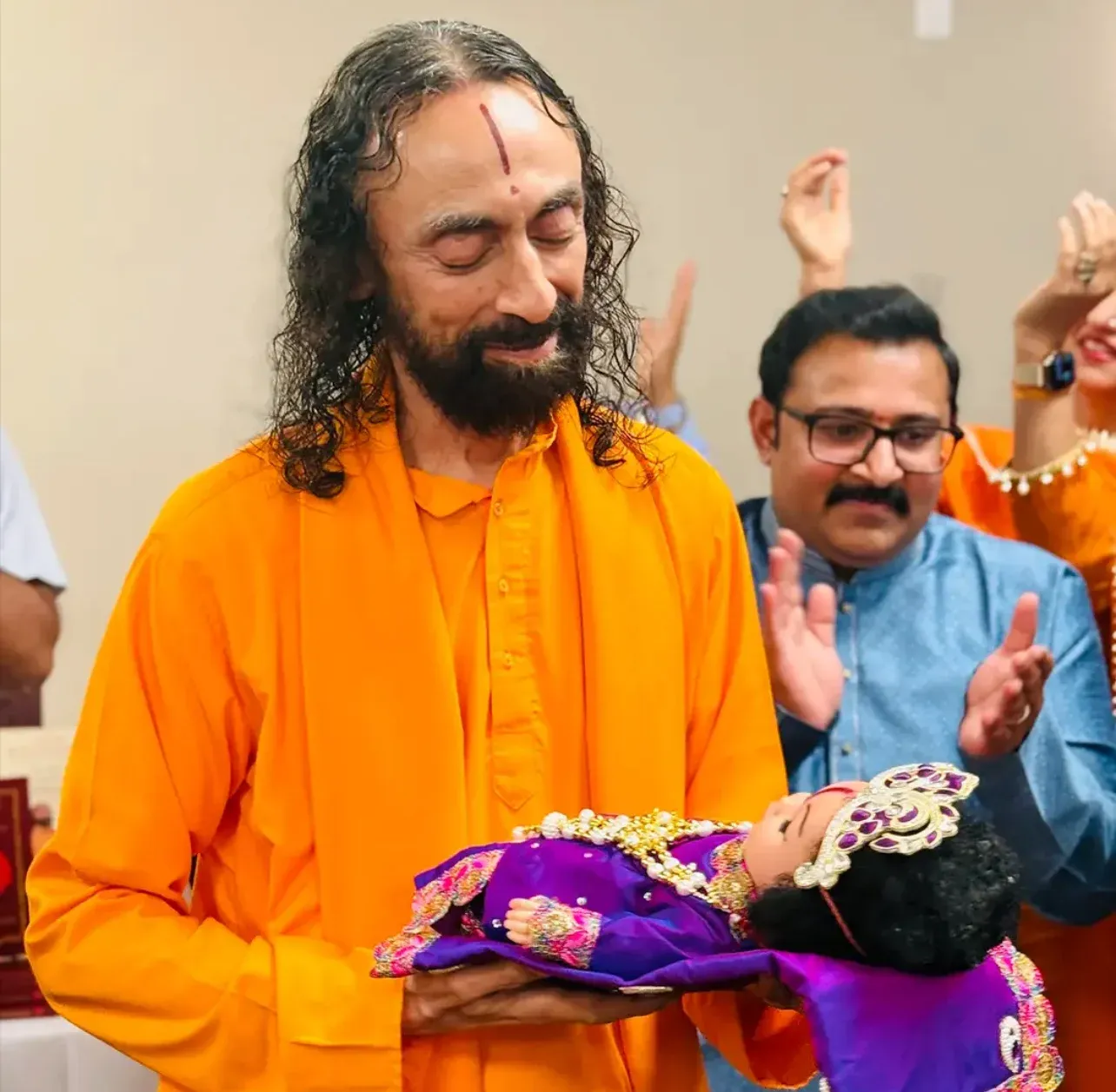 Swami Mukundananda holds Bal Ram with a loving gaze