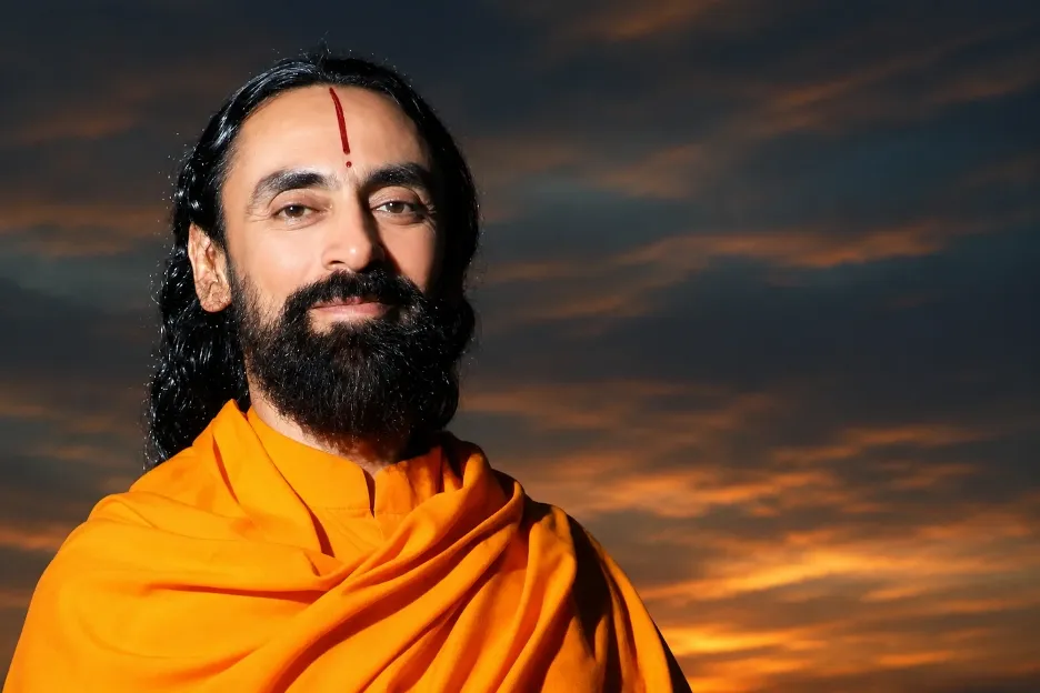 Portrait of Swami Mukundananda in saffron robes against a dramatic sunset sky, radiating serenity, wisdom, and spiritual grace.