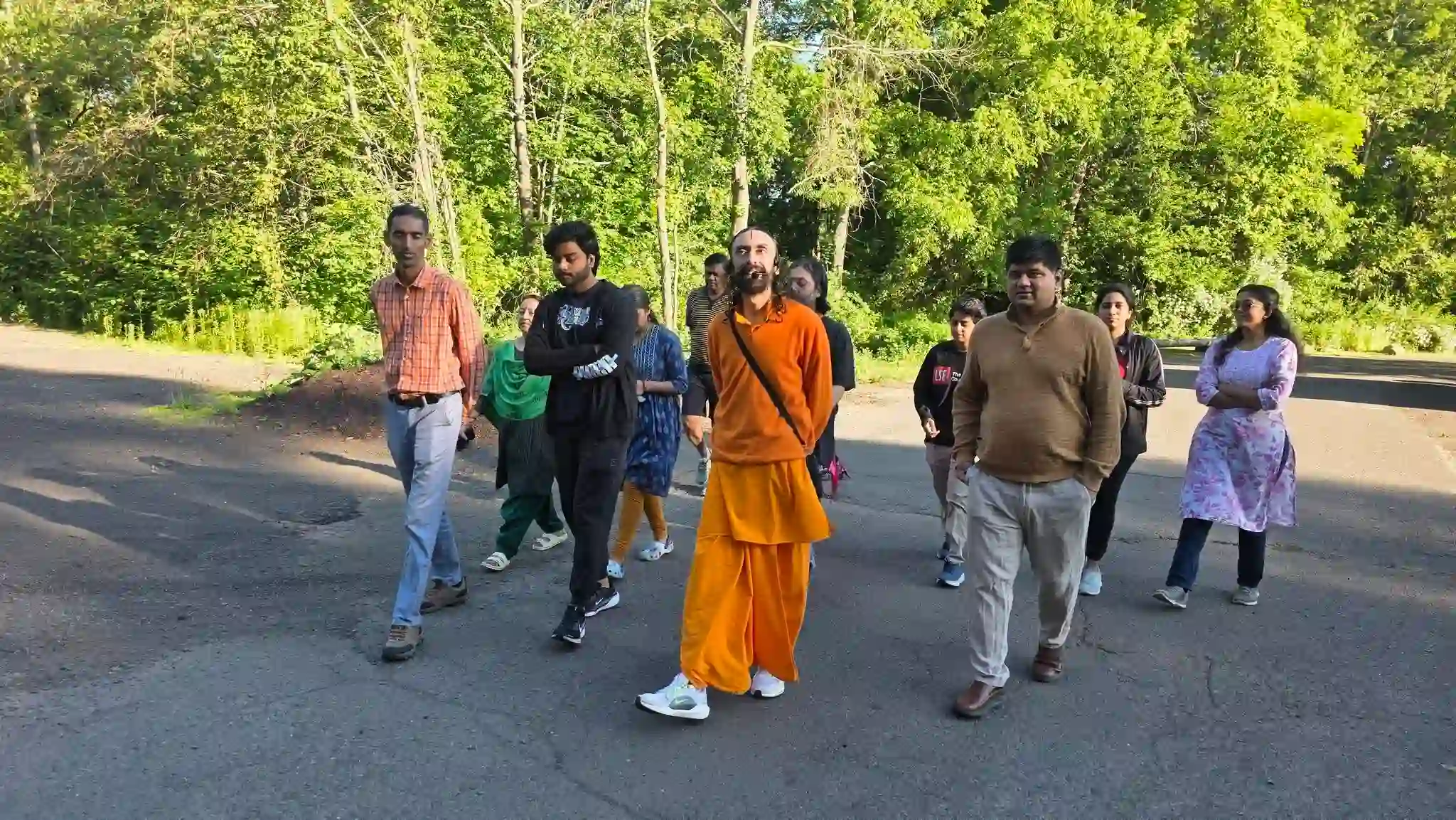 Swami Mukundananda walking outdoors with devotees during the 2026 Connecticut Life Transformation Program.